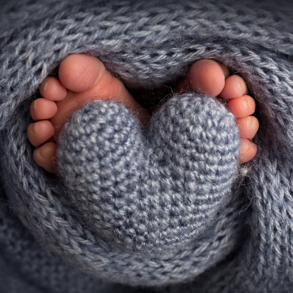 due piedini di bebè in una coperta di lana